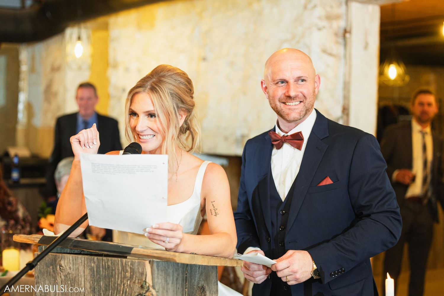 A couple reads from papers during their wedding reception speech.