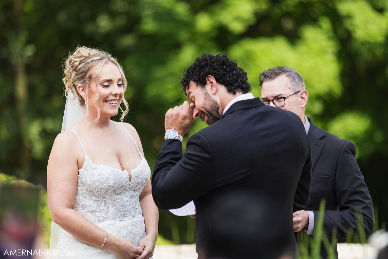 Candid moment during outdoor wedding ceremony showing emotional exchange between couple.