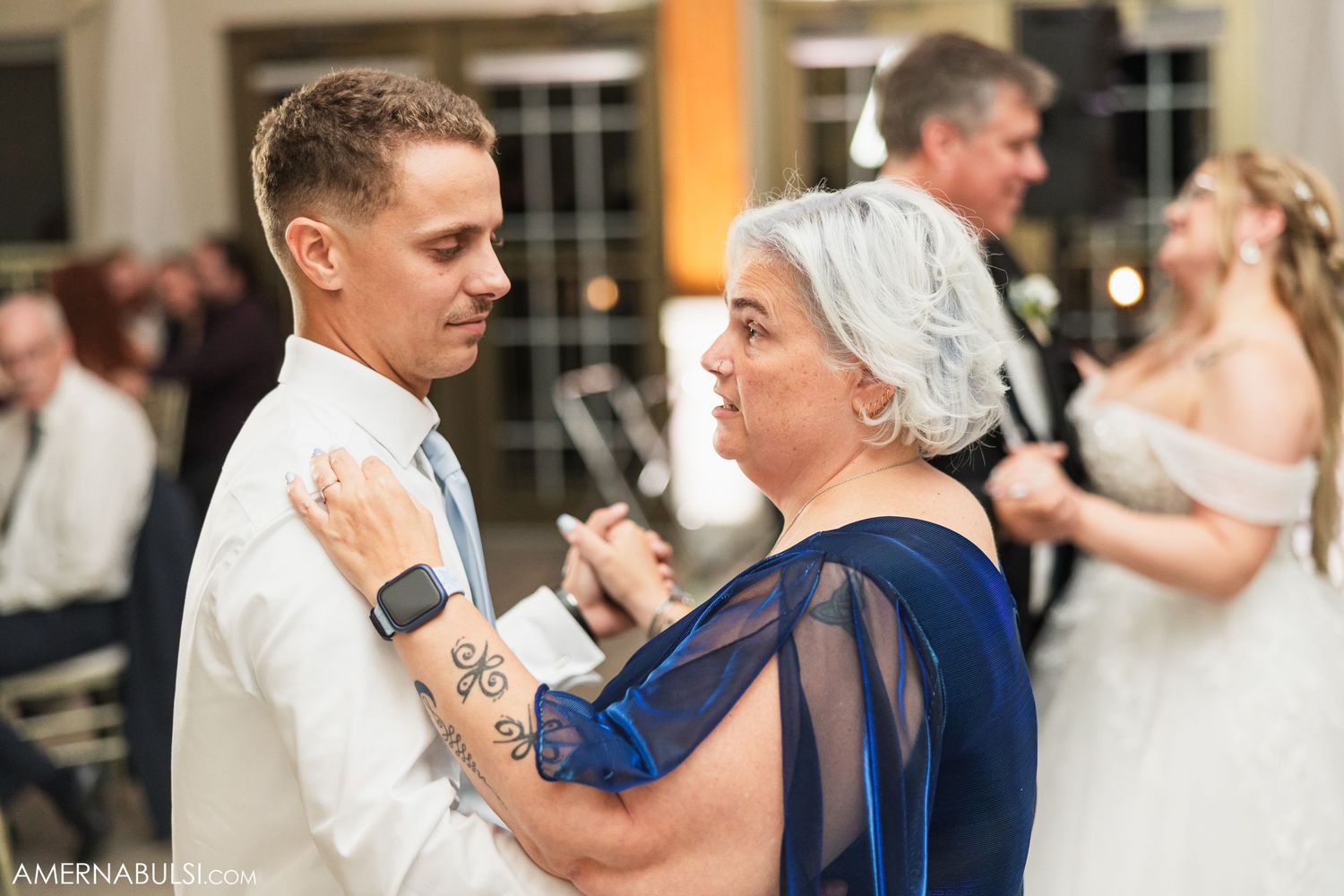 Wedding guests celebrate with dancing at an elegant indoor reception venue.
