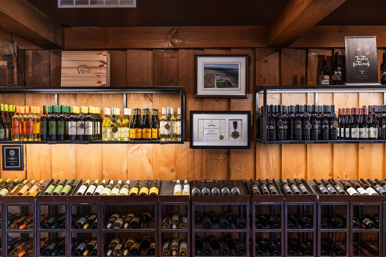 Illuminated bar shelving with extensive wine bottle collection and warm wooden interior.