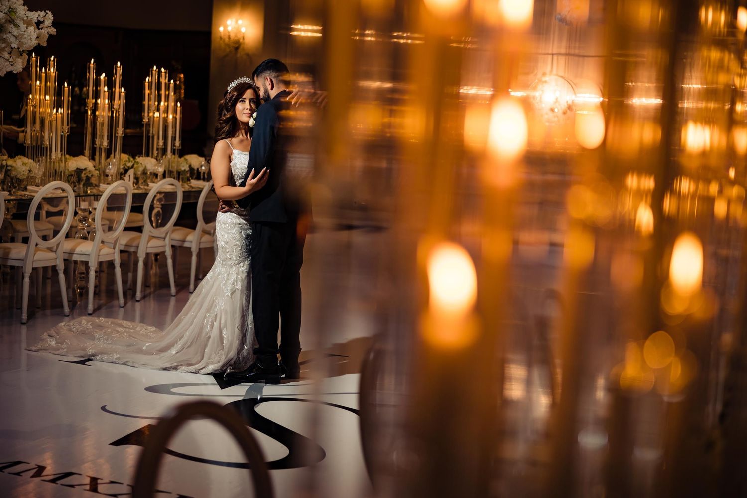 Romantic wedding dance captured through candlelight in an elegant reception venue.