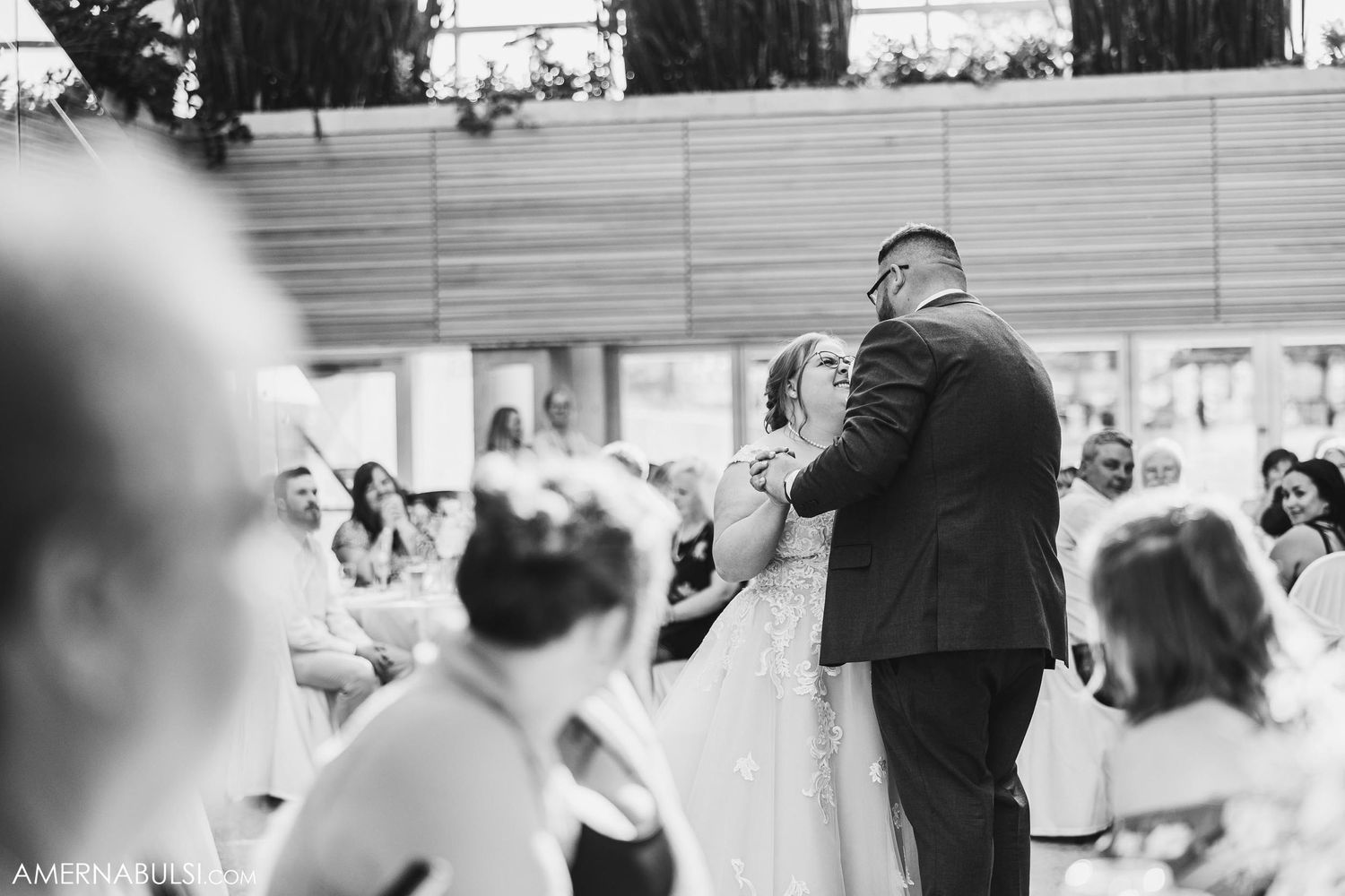 A black and white photo of a couple embracing during their wedding dance.