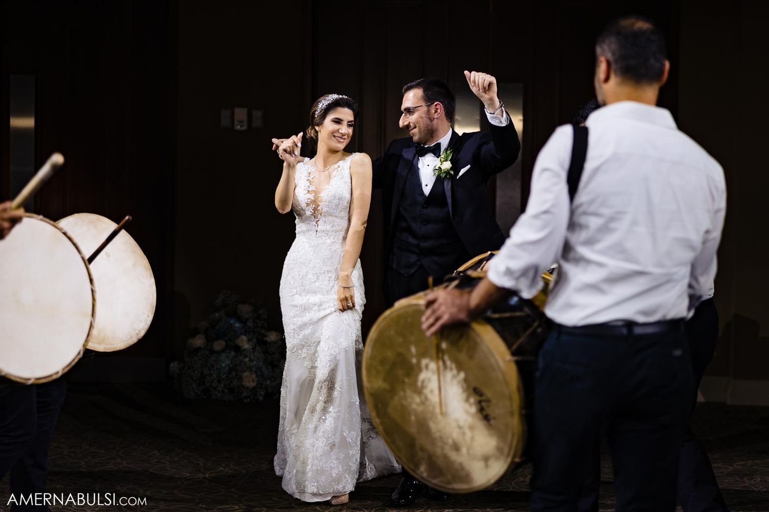 Musicians with traditional drums create music while a couple dances at their wedding celebration.