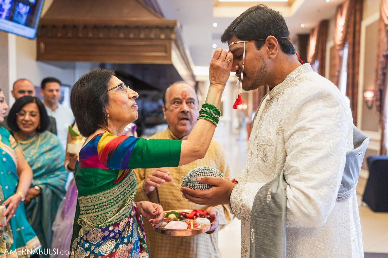 Traditional blessing ceremony with participants in vibrant Indian attire.