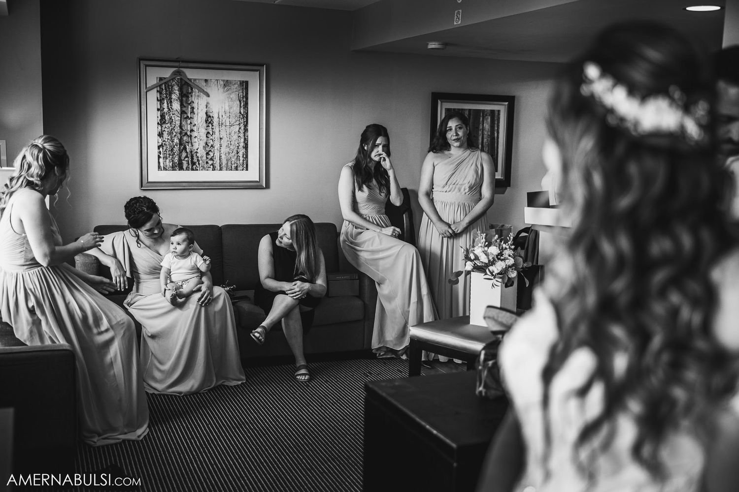 A black and white photo of a quiet moment during wedding preparations in a hotel room.