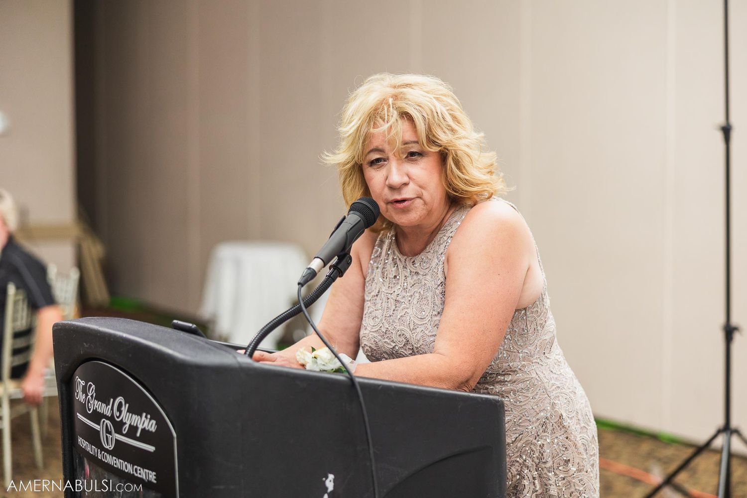 Speaker delivers emotional speech at formal event podium.