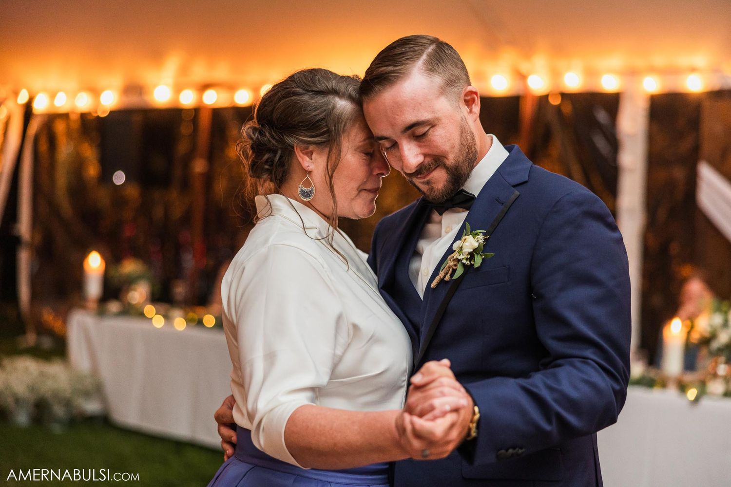 Intimate first dance moment between newlyweds under warm outdoor lighting.