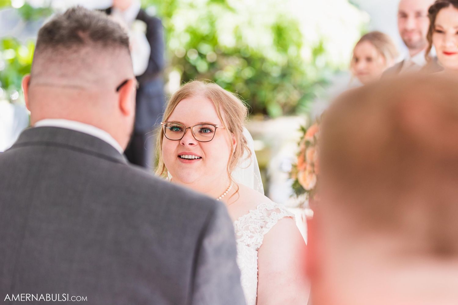 Joyful exchange of vows during outdoor tent wedding ceremony.