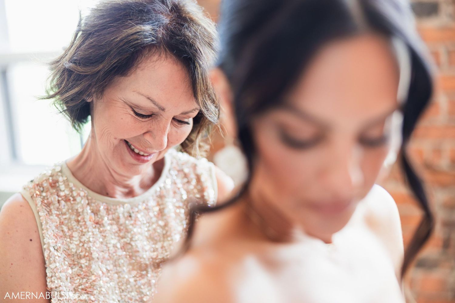 Candid moment captured between two women during wedding preparations.