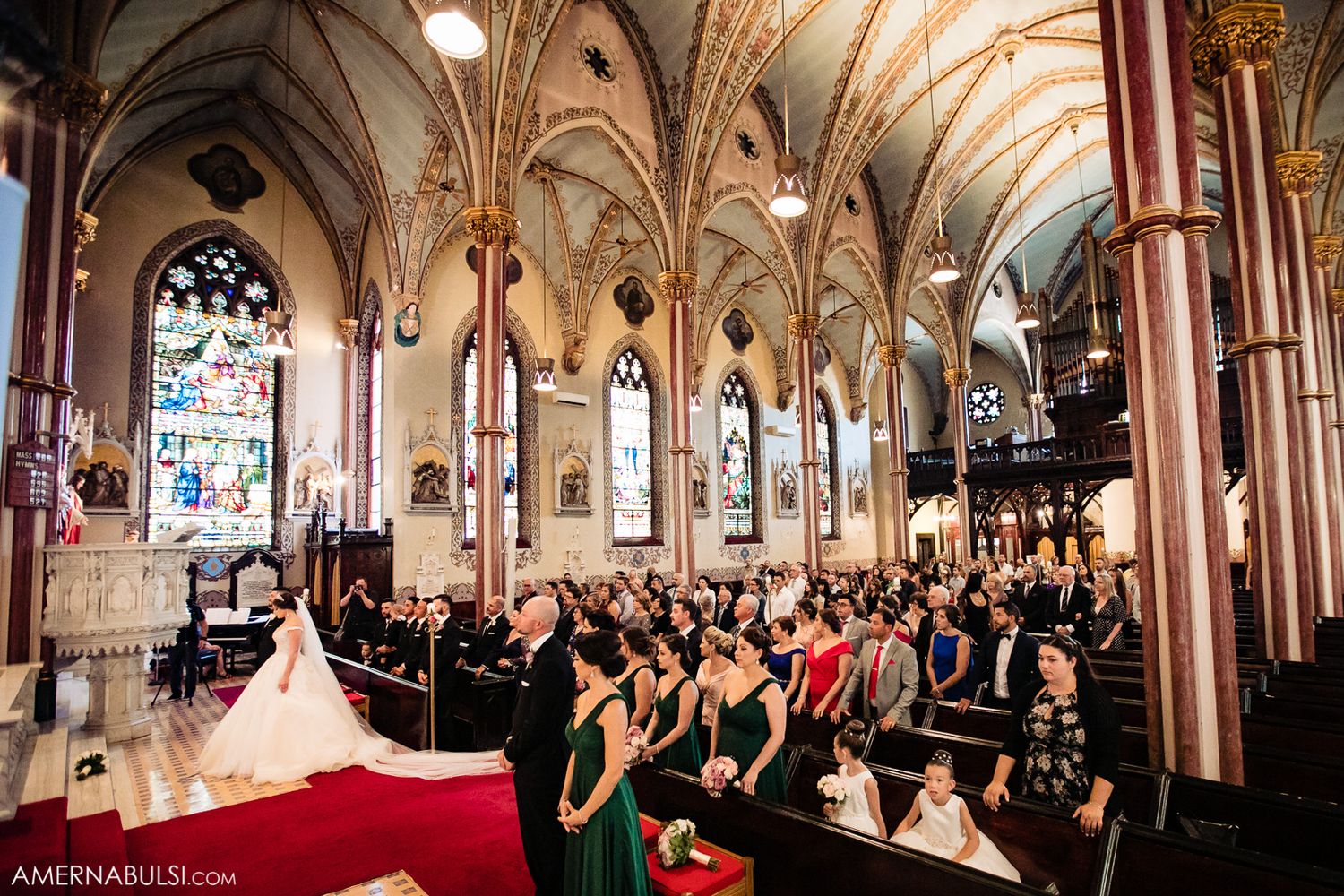 Cathedral wedding ceremony in a stunning Gothic church with vaulted ceilings and stained glass windows.