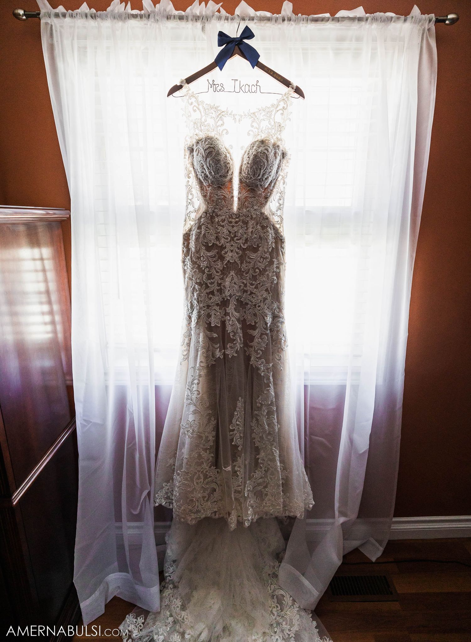Hands carefully working on wedding dress details in an intimate preparation moment.