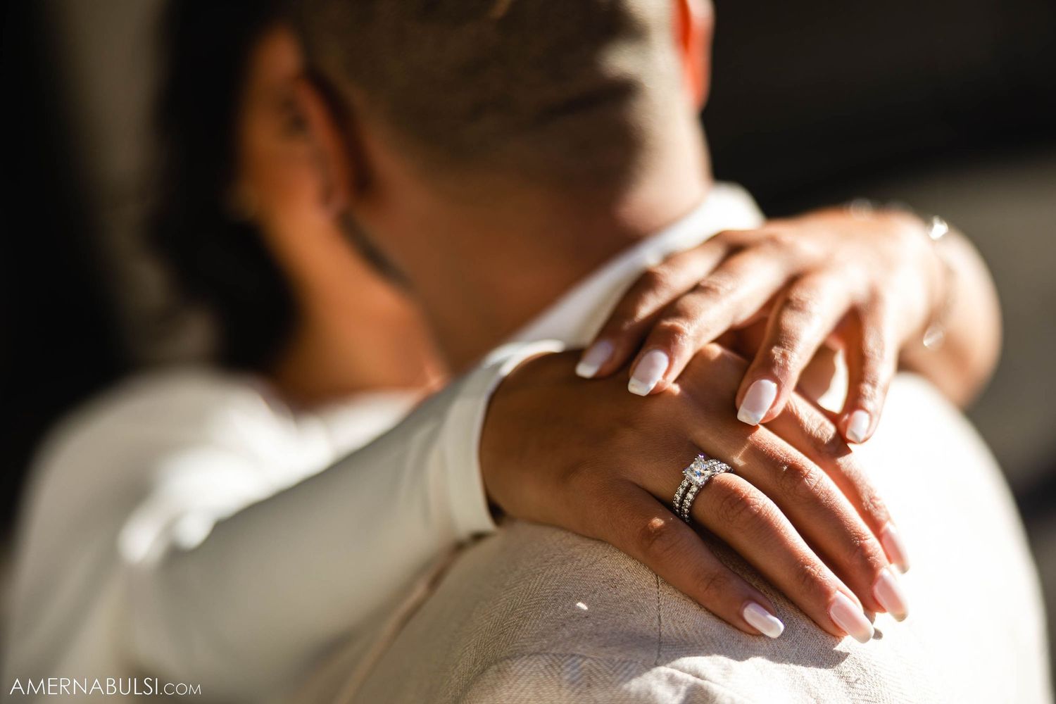 Close-up shot of hands with wedding rings in an intimate embrace.