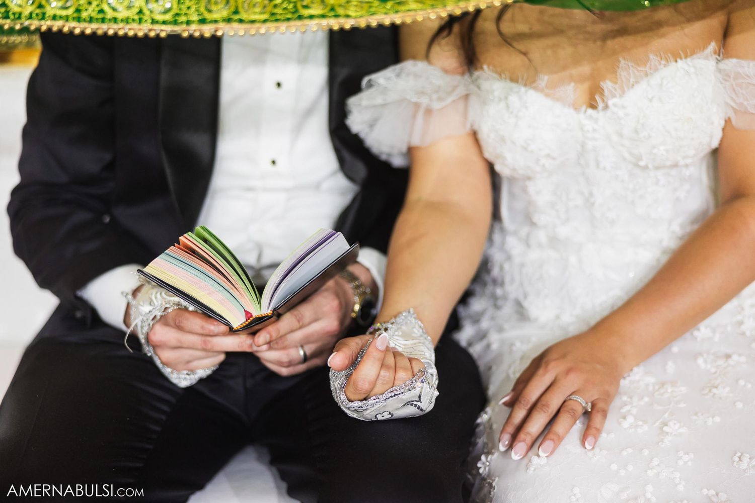 Detail shot of couple holding prayer books during wedding ceremony.
