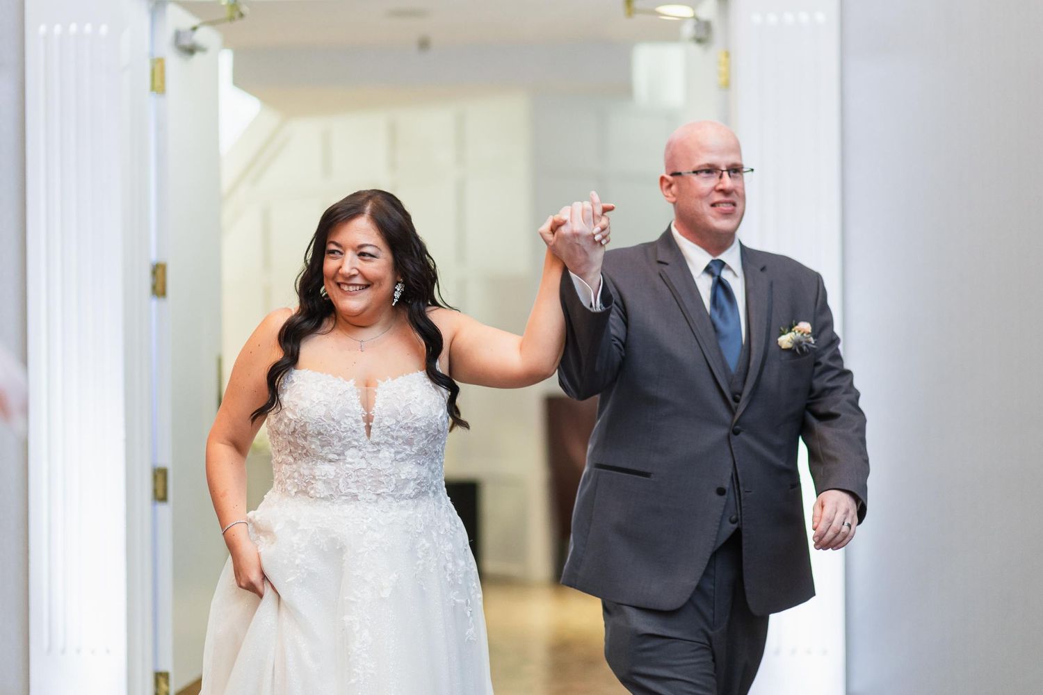 A joyful couple celebrating as they make their grand entrance at their wedding reception.
