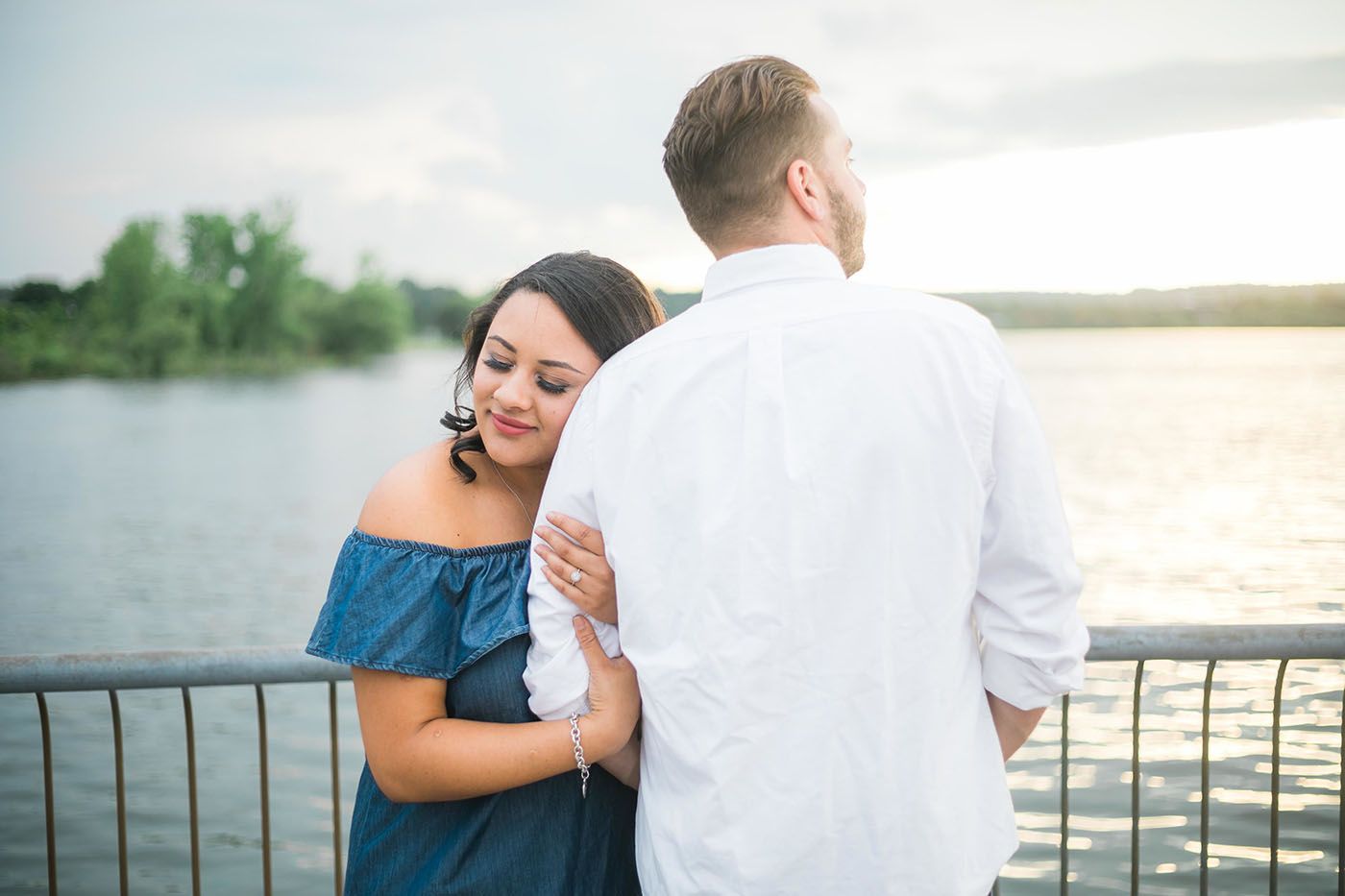 A romantic moment captured on a waterfront dock during sunset.