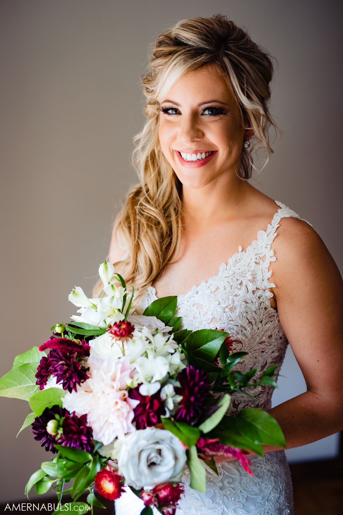A bridal portrait series showcasing a white lace wedding dress and vibrant burgundy and white floral bouquet.