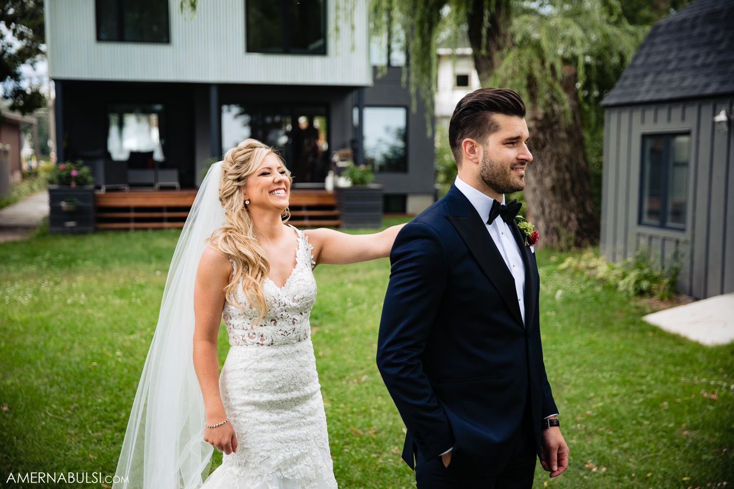 Wedding couple poses together in an outdoor garden setting.
