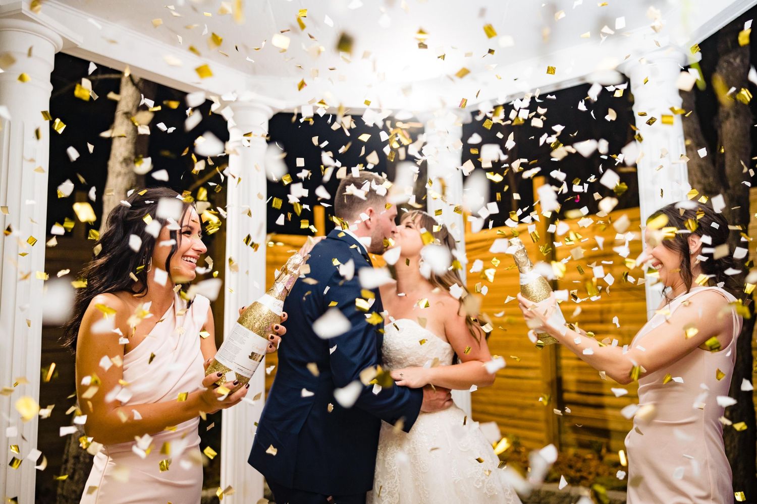 Celebration with guests at an indoor venue as gold and white confetti rains down during a joyous moment.