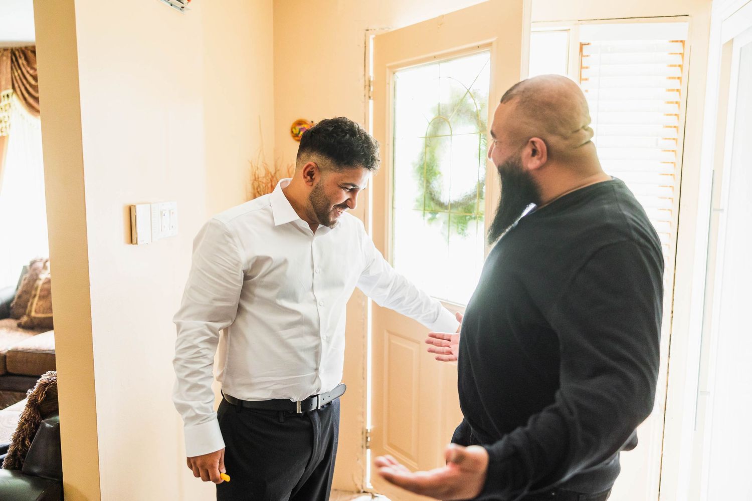 Two men engaged in conversation in a bright indoor setting.