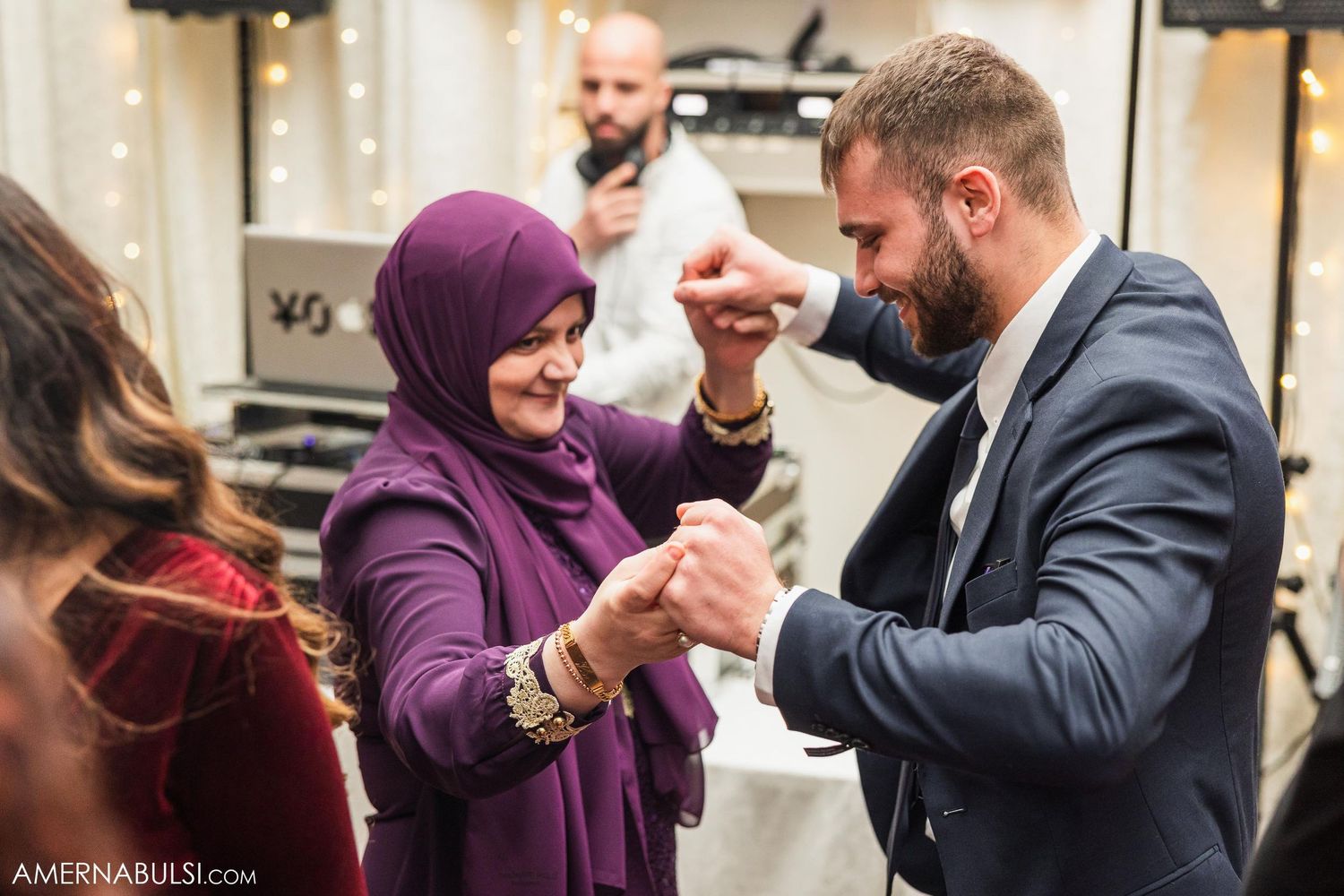 Two guests sharing a playful dance moment at an indoor celebration.