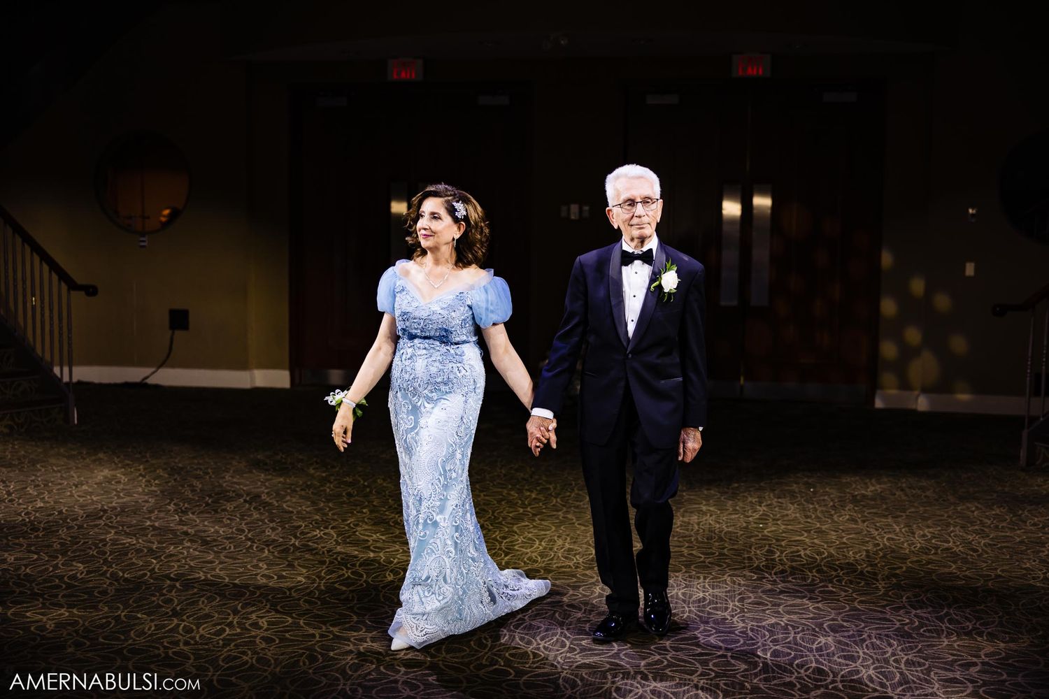 Evening outdoor portrait of couple in formal attire walking together.