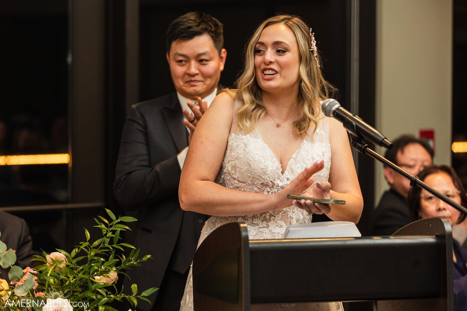 Wedding couple delivering emotional speeches at reception with floral decorations.