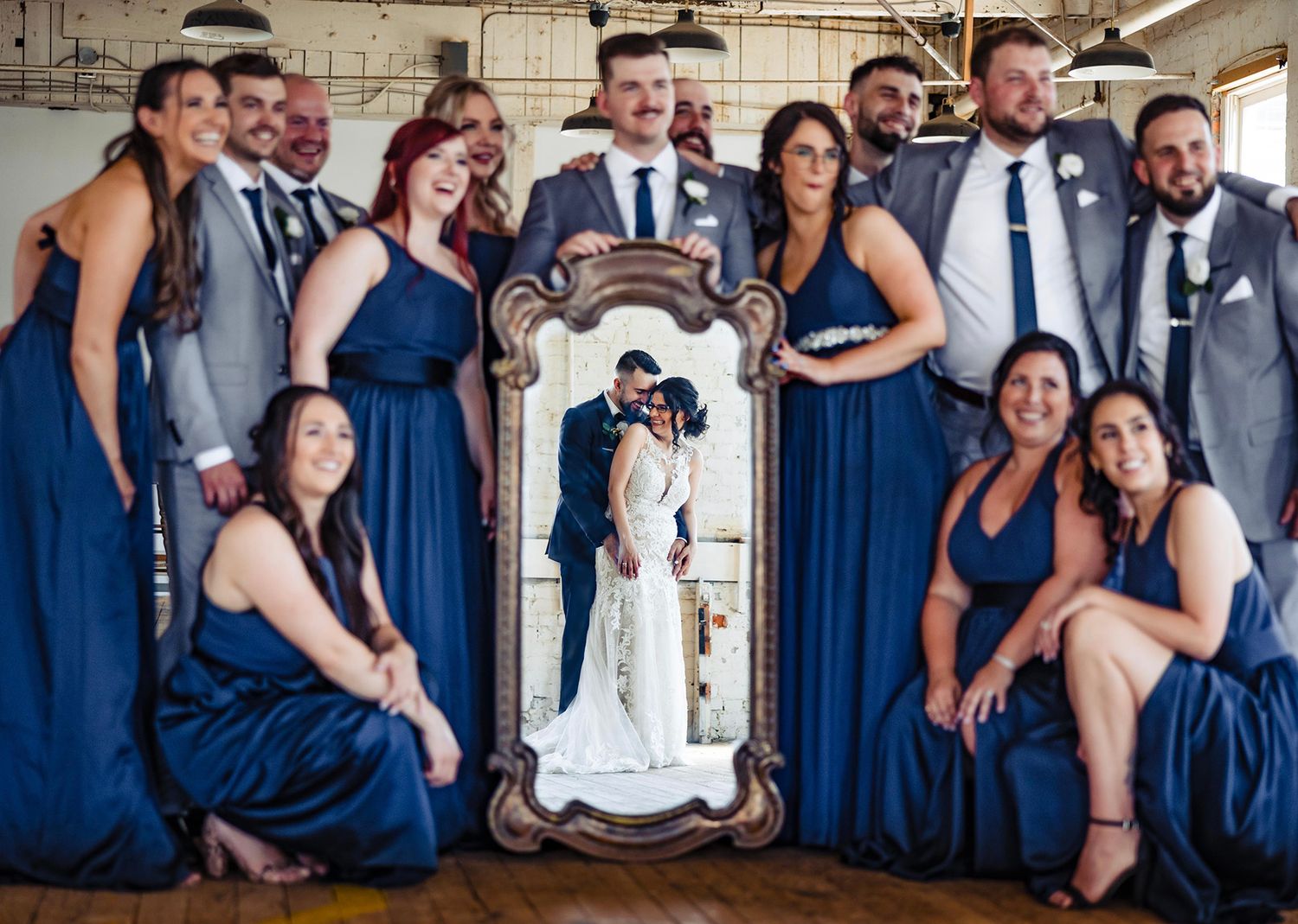 Wedding party poses in navy blue attire for creative group photo.