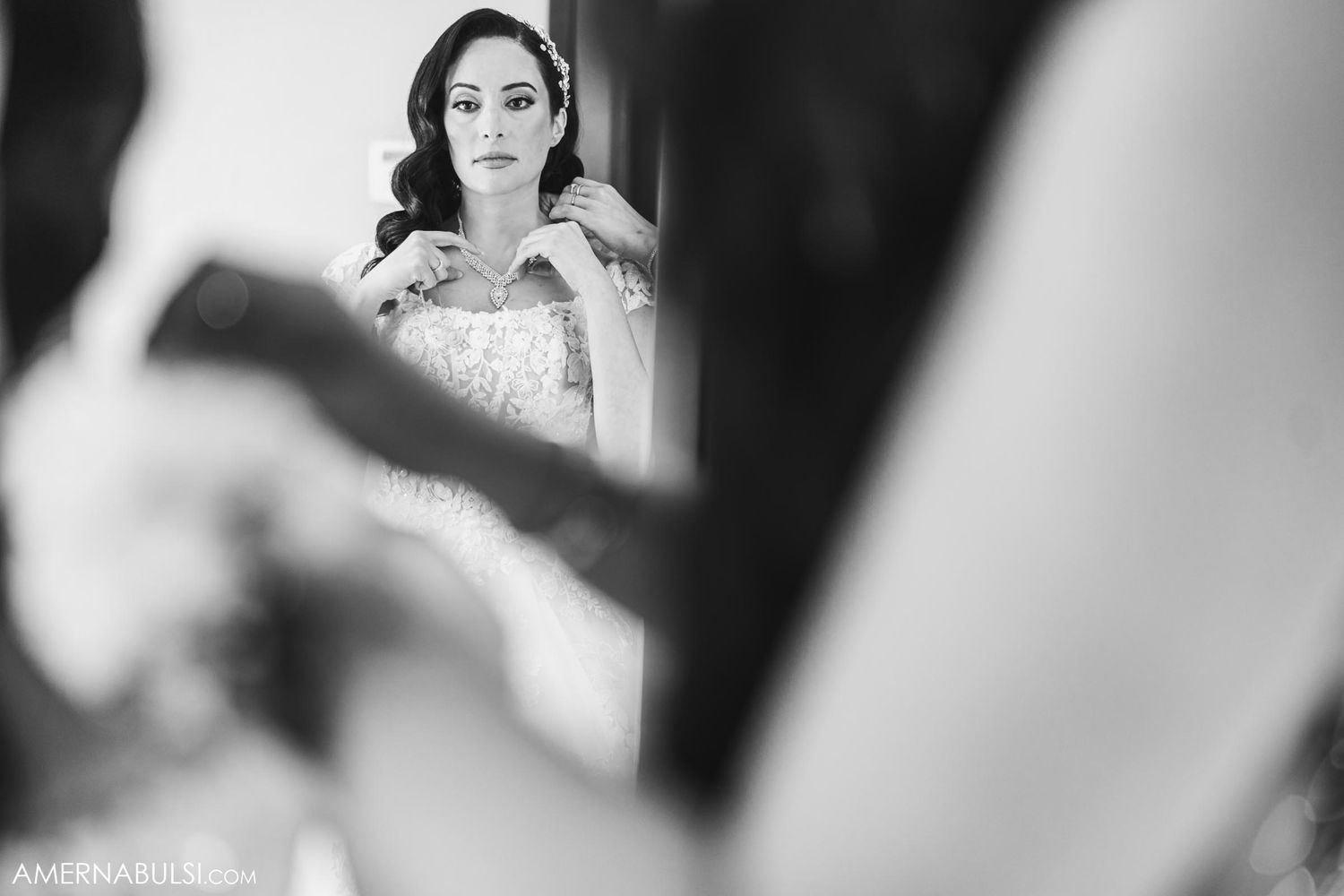 Artistic black and white reflection of bride getting ready in mirror.
