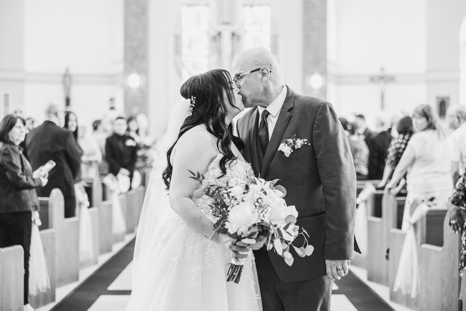 A joyful wedding ceremony moment captured in black and white inside a traditional church.