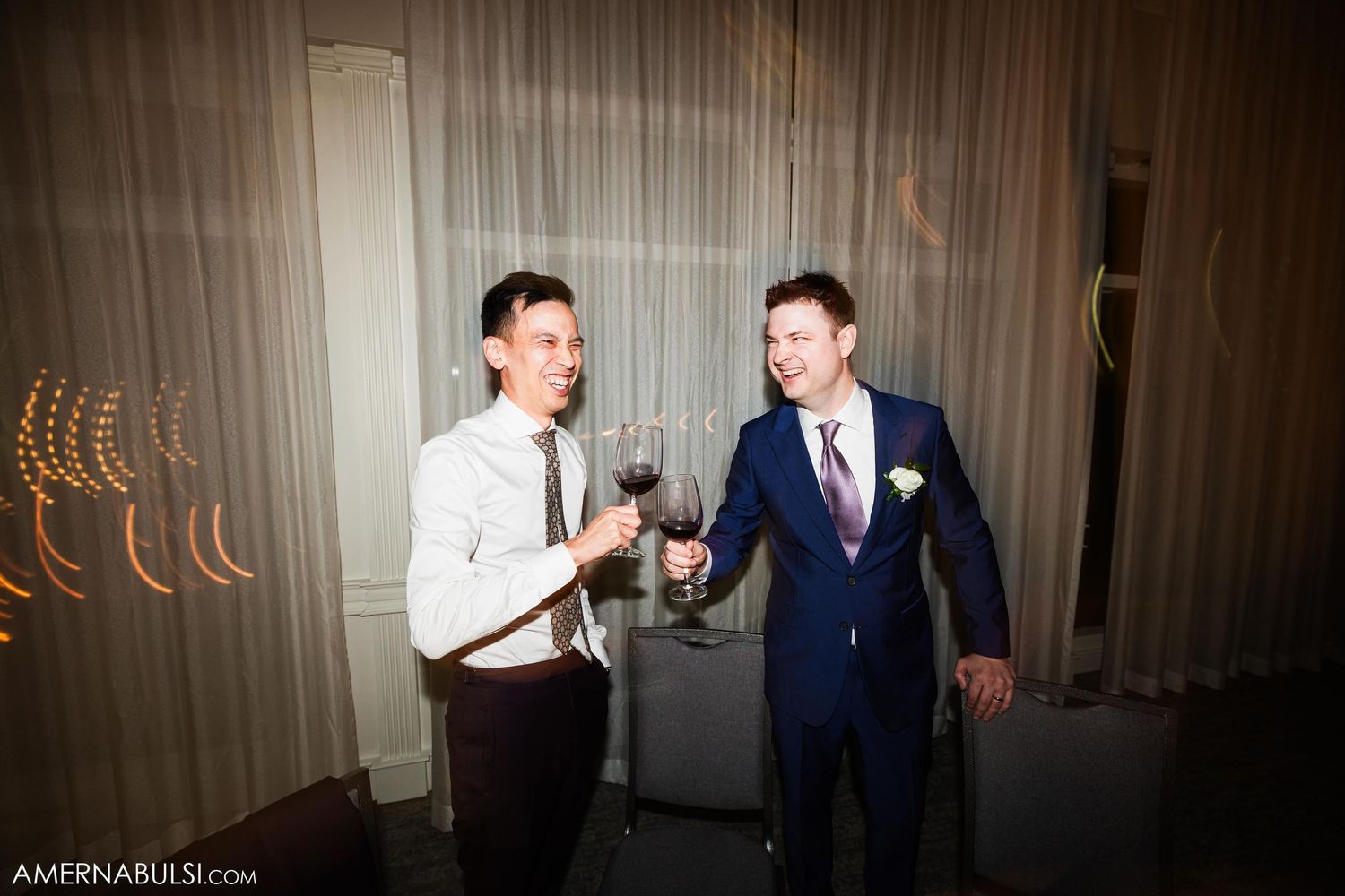 Two people sharing drinks and laughs at an evening celebration.