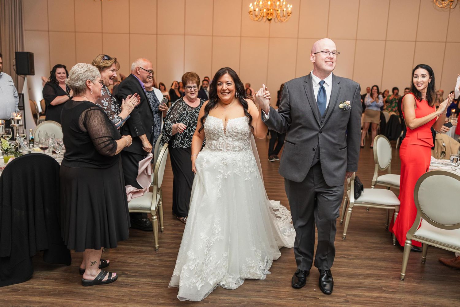 Wedding reception entrance with guests clapping and celebrating.