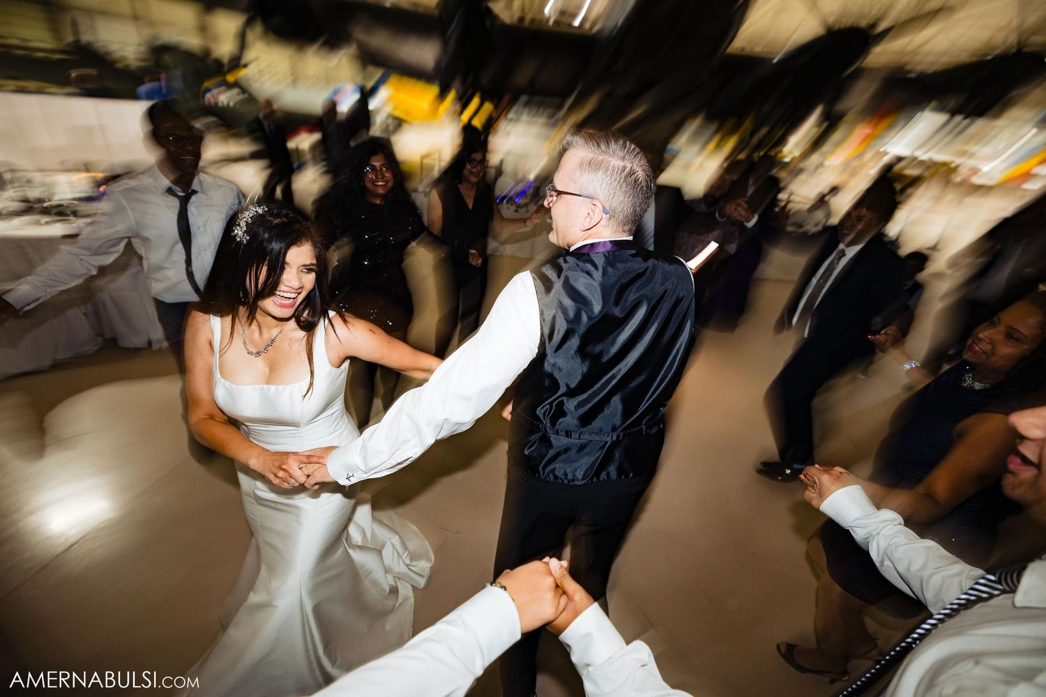 Wedding reception dance floor moment captured with dramatic motion blur effects.