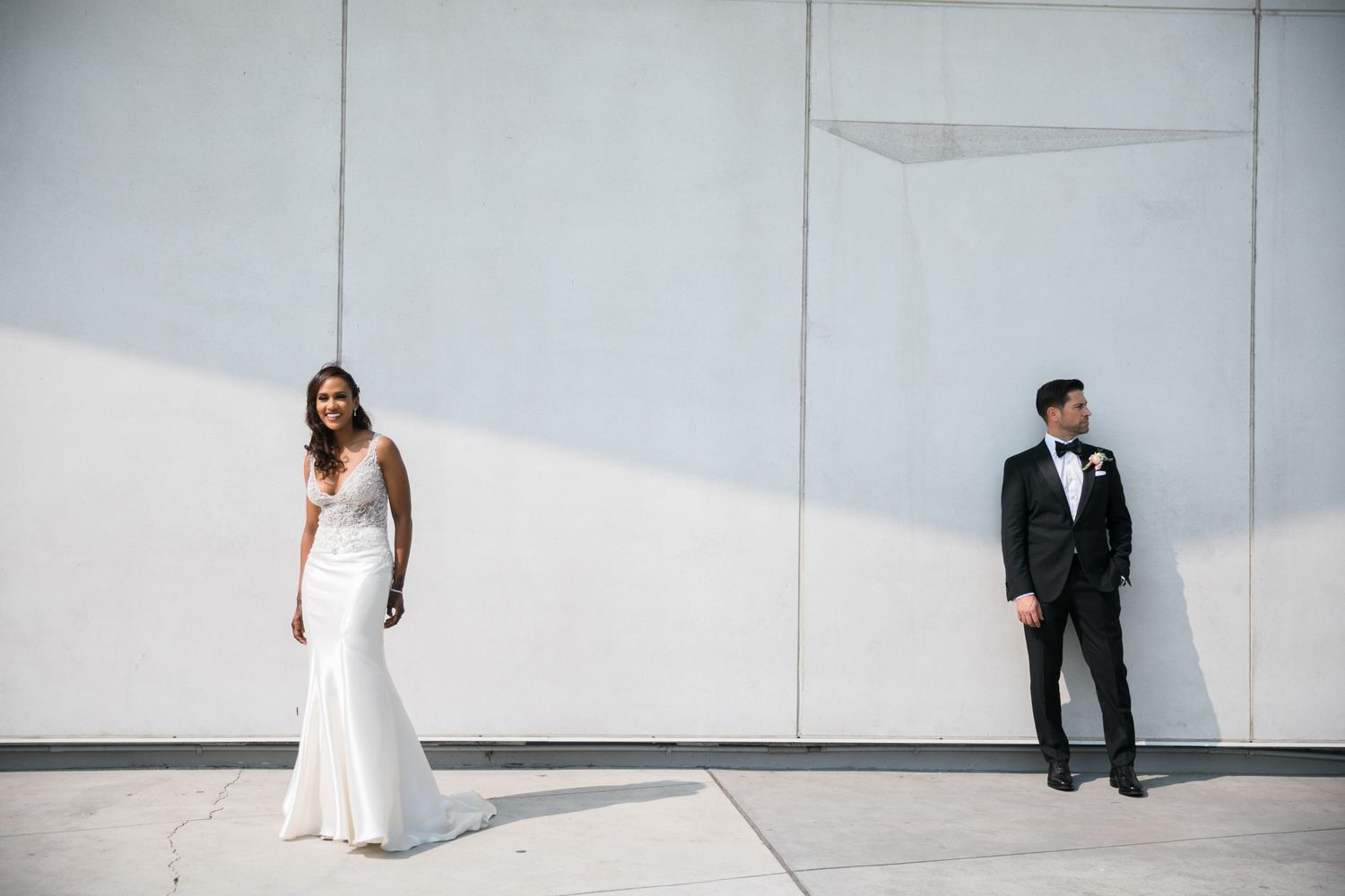 Minimalist wedding photo shoot against white wall backdrop.