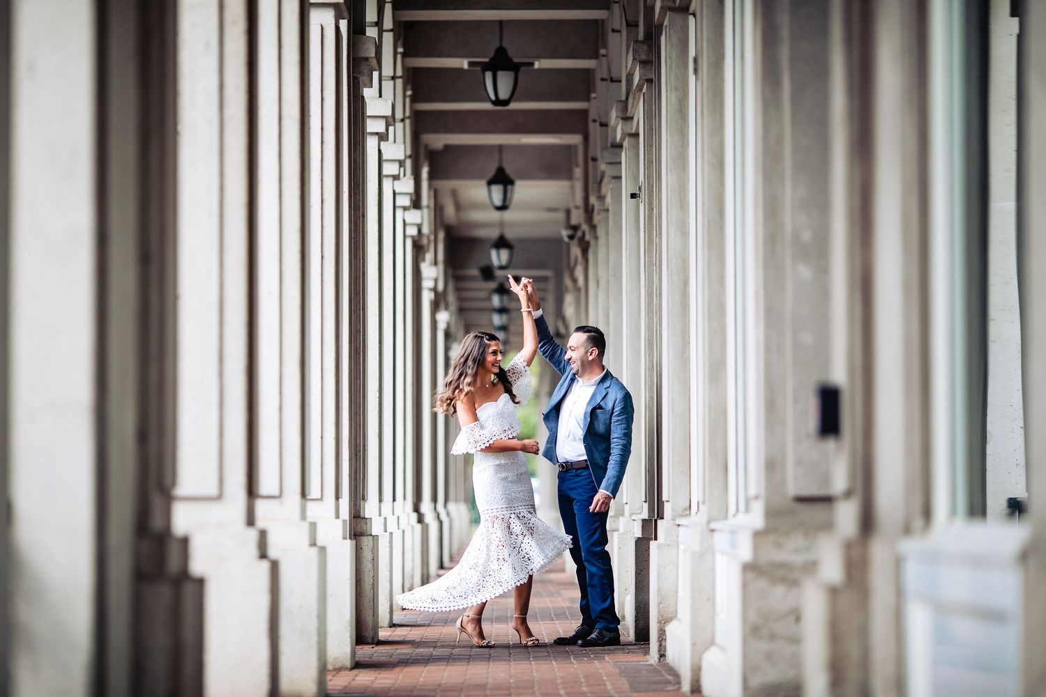 An elegant architectural corridor with columns creates dramatic lighting and perspective.