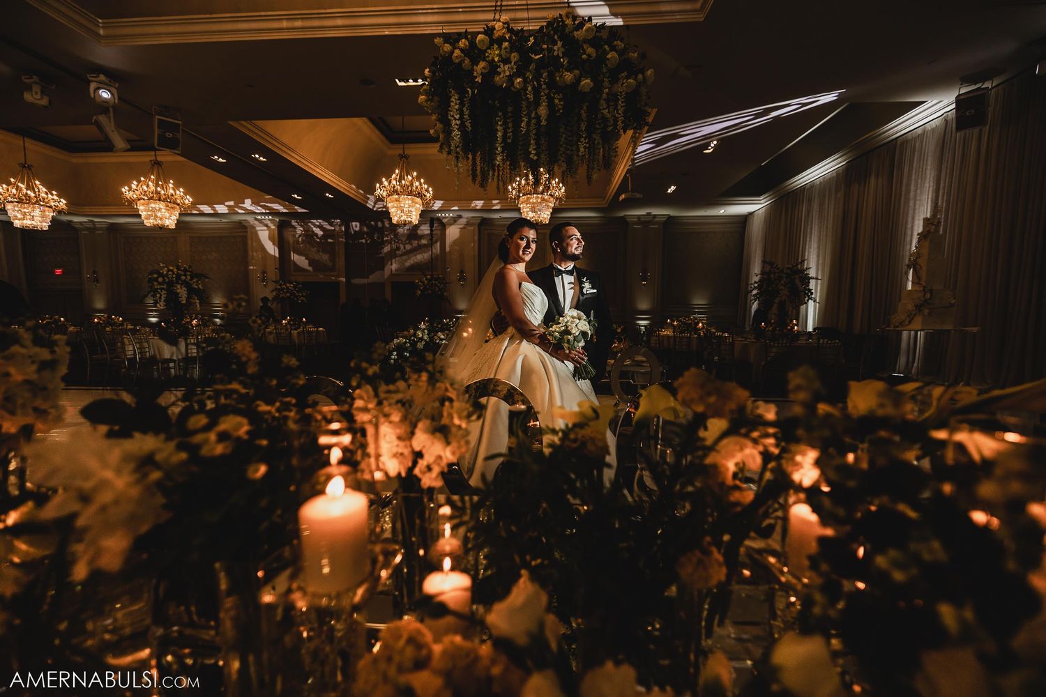 Intimate candlelit wedding scene with soft lighting and lush floral decorations.