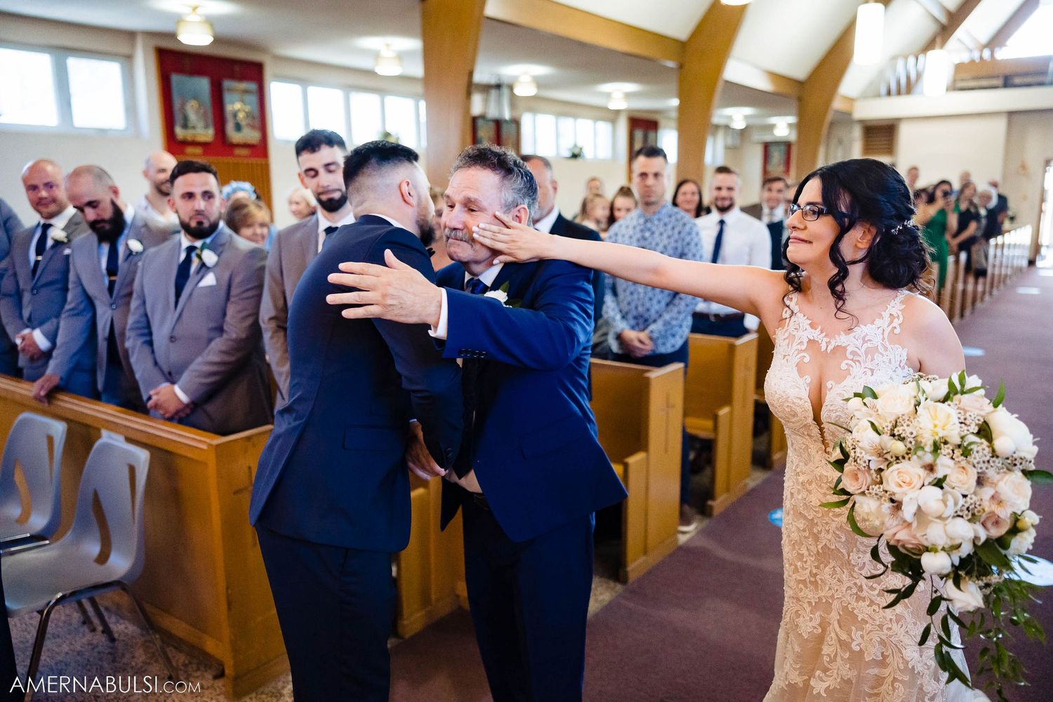 Bride wearing glasses smiles joyfully during wedding ceremony moment.