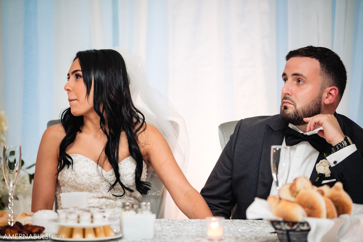 Wedding reception table scene with guests enjoying dinner conversation.