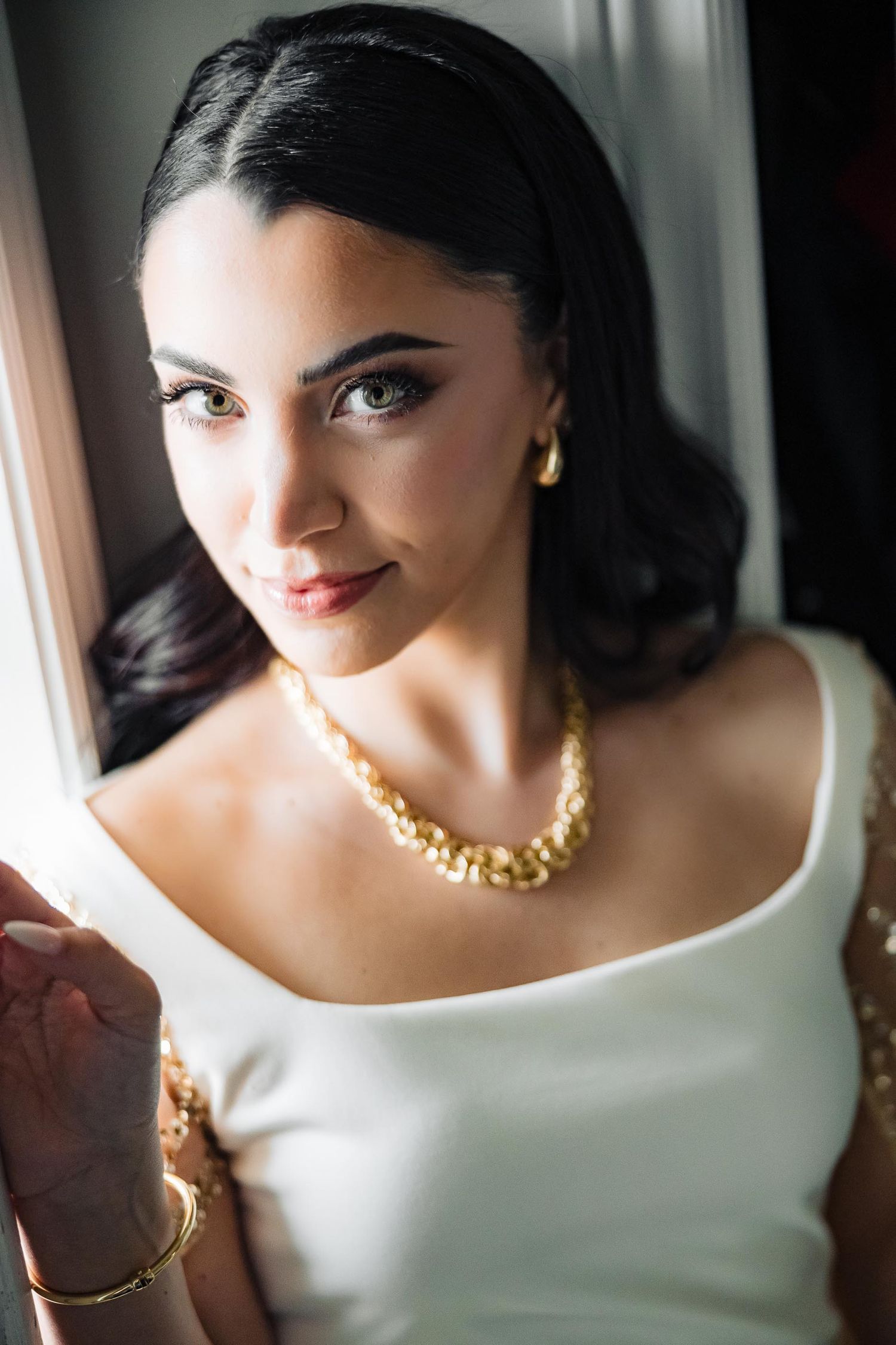An elegant portrait showcasing classic bridal styling with jewelry and makeup.