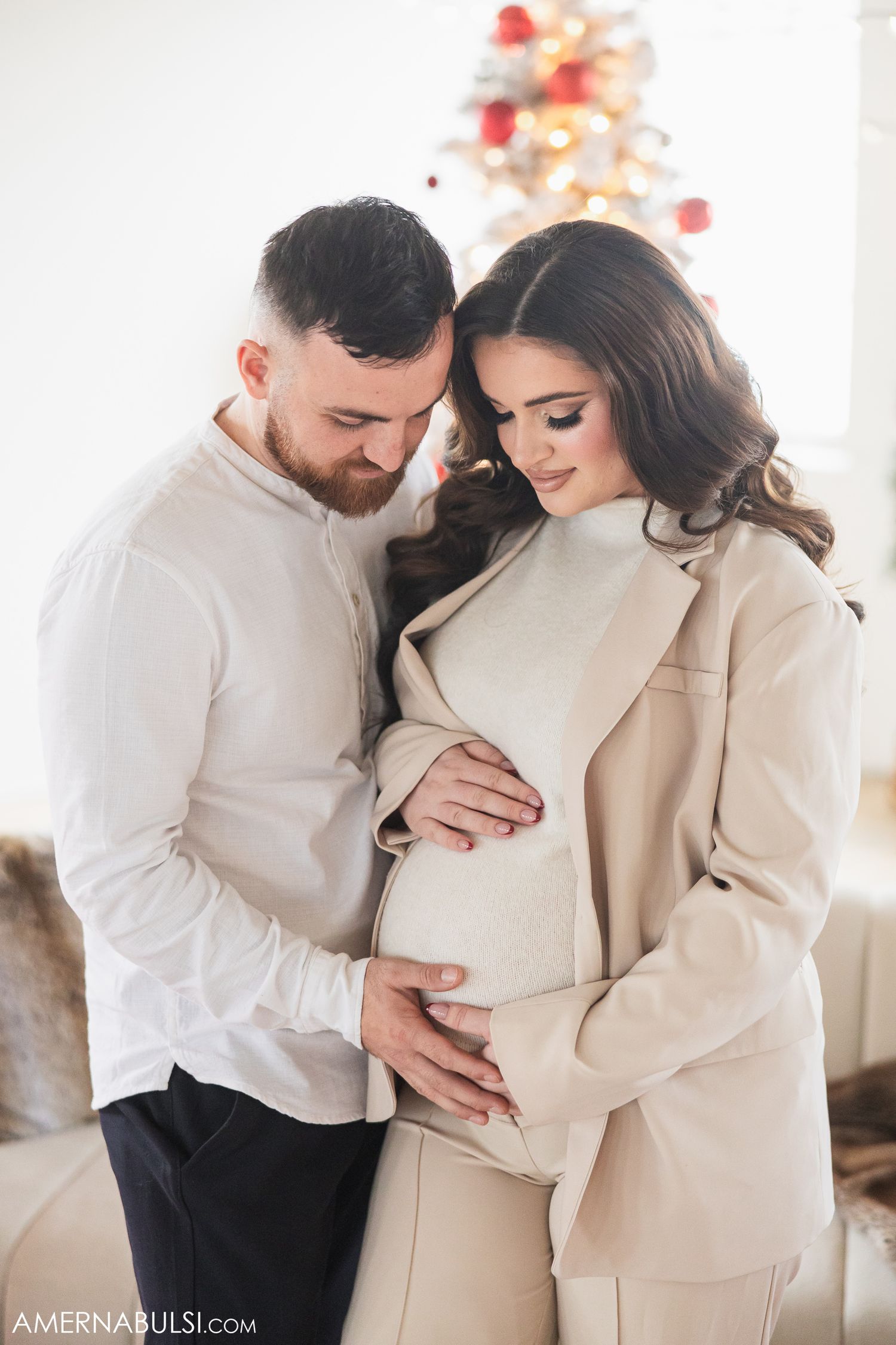 A maternity session, the dad is touching his wife's belly to feel a baby bump