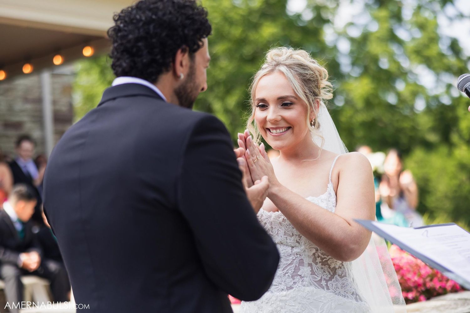 A joyful moment captured during a wedding ceremony as the couple exchanges vows outdoors.