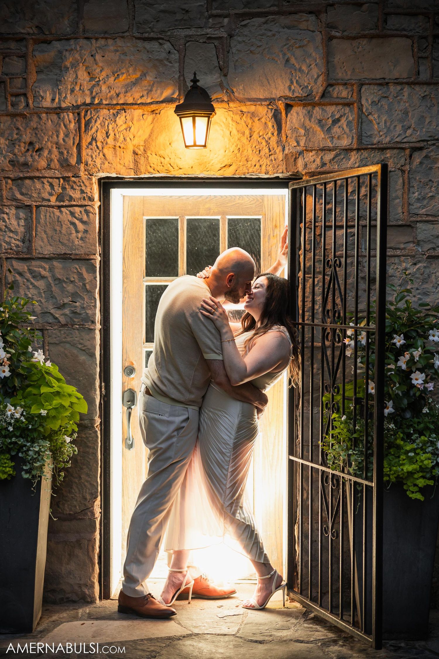 Romantic silhouette of a couple sharing an intimate moment in a warmly lit doorway.