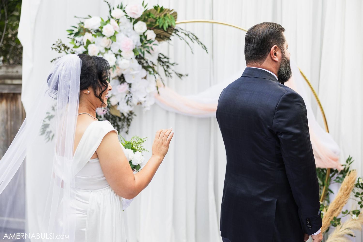 Bride and groom participate in first look moment at outdoor garden wedding.