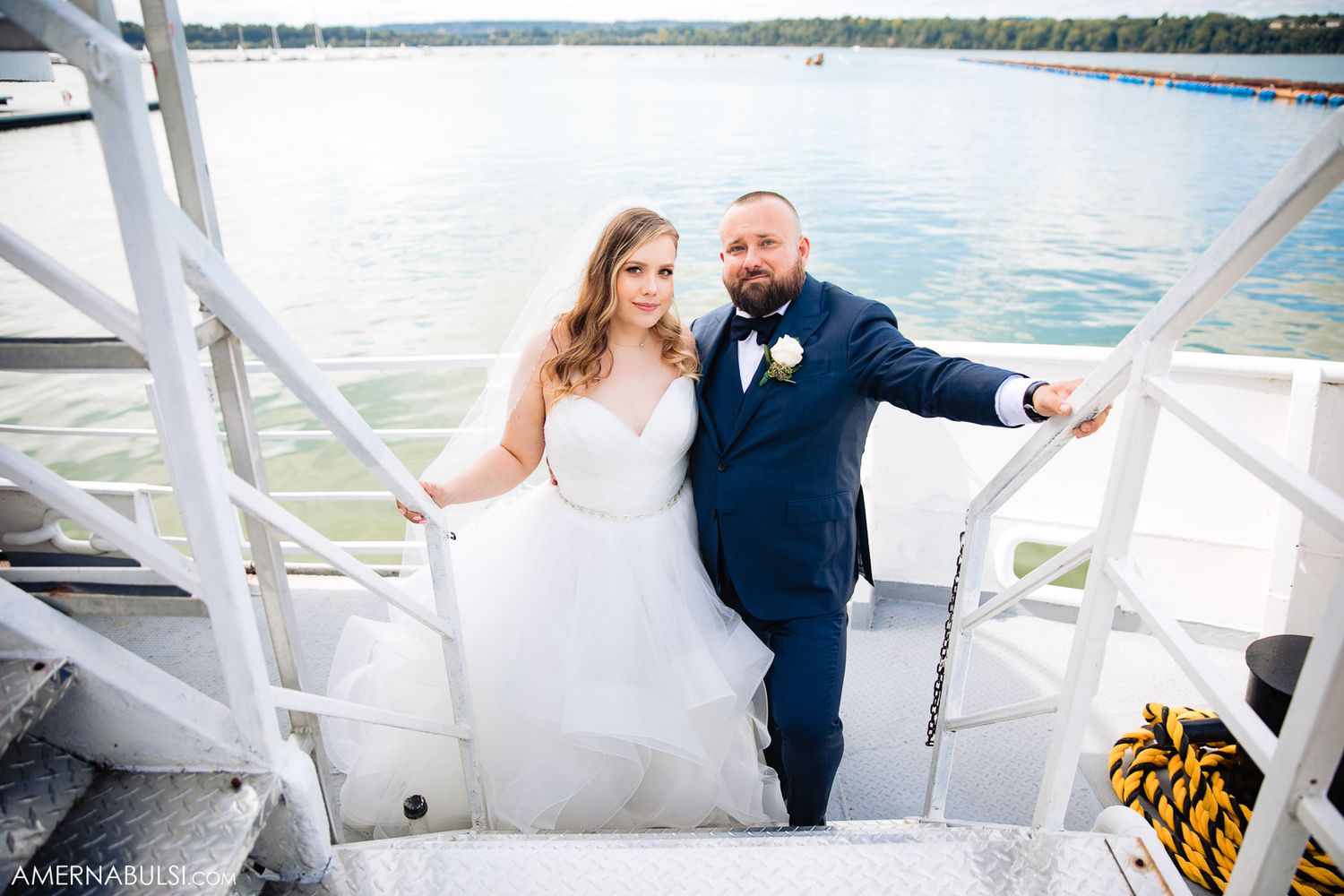 Wedding couple enjoying a scenic boat ride on a bright sunny day near the water.