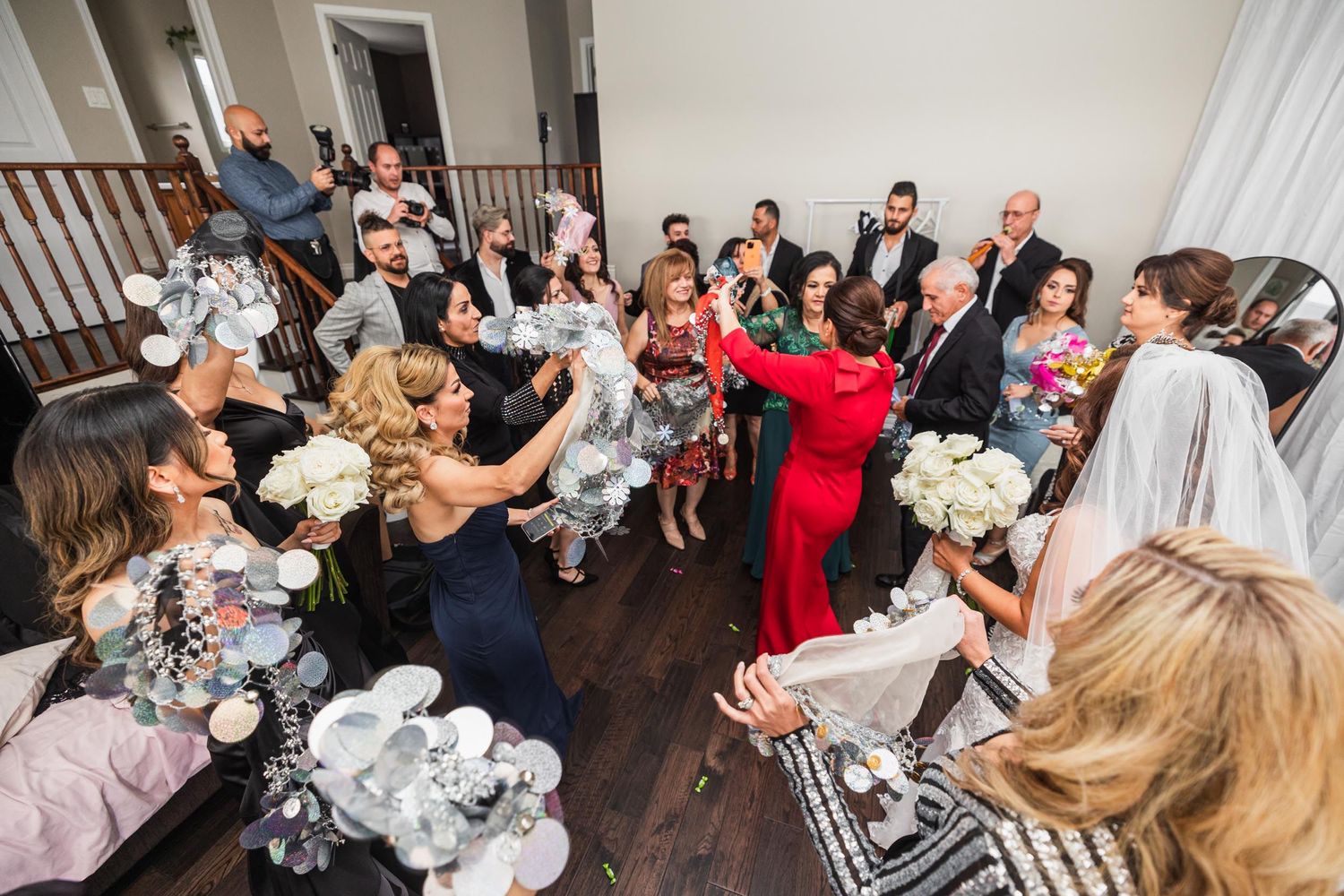 A lively wedding reception party with guests dancing and celebrating on a wooden floor.