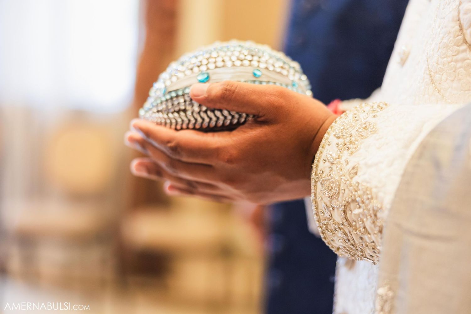 Close-up of hands holding ornate ceremonial items during a wedding ritual.