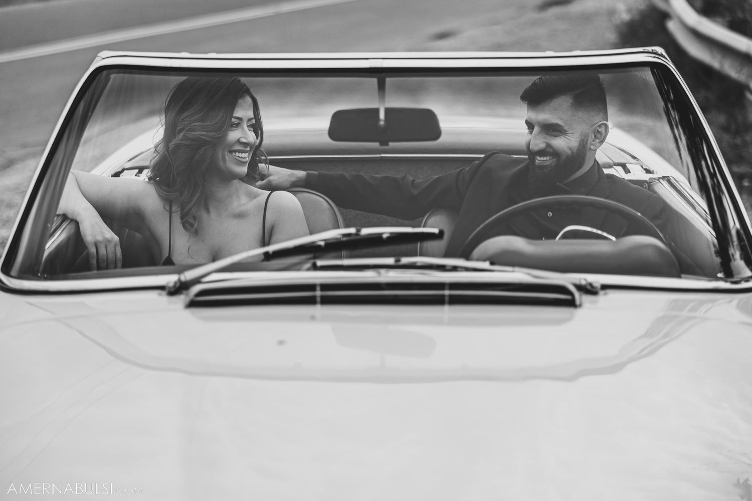 Black and white photo of joyful moment in classic convertible Mercedes.
