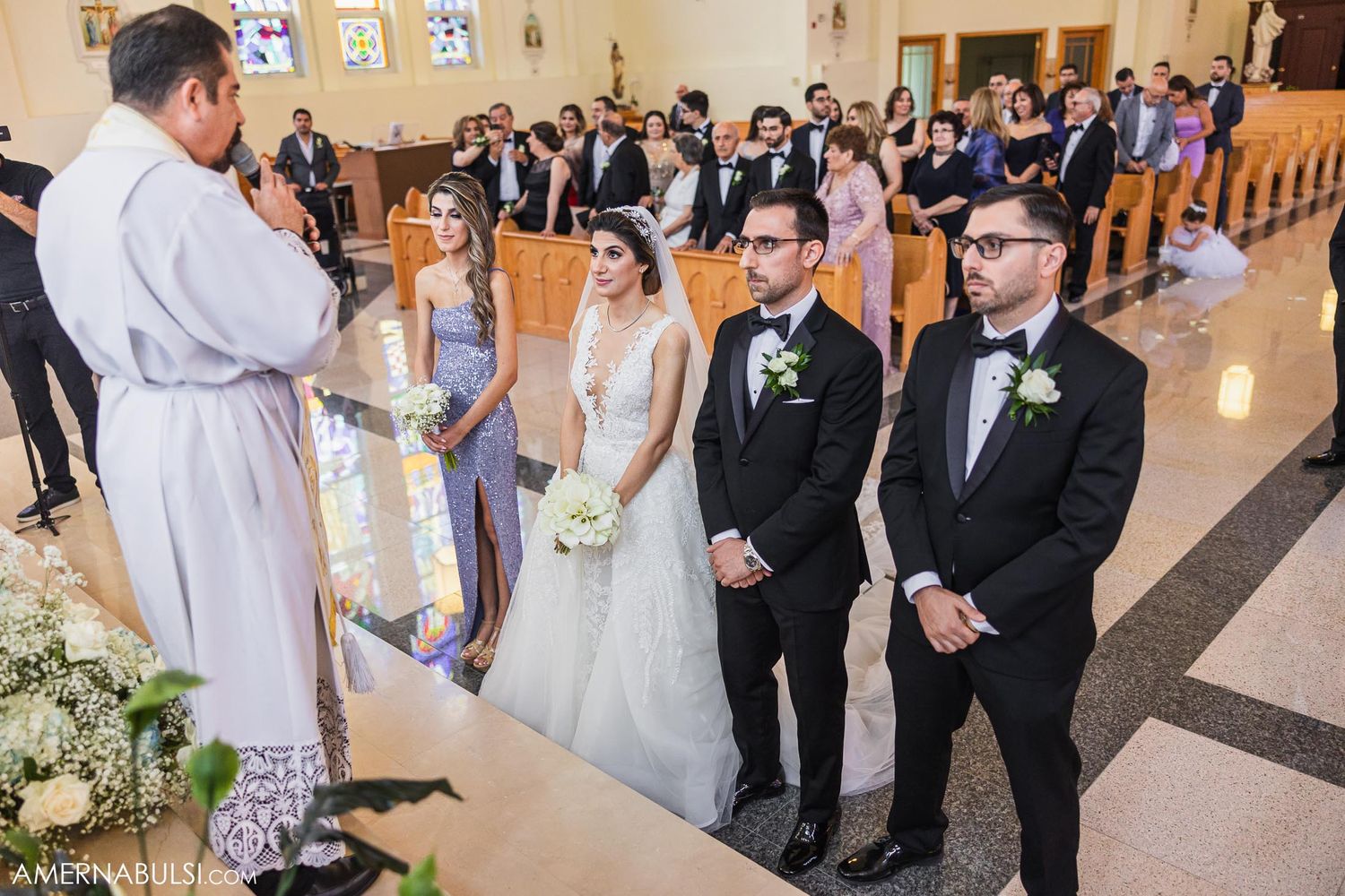 A religious wedding ceremony unfolds in a traditional church with stained glass windows.