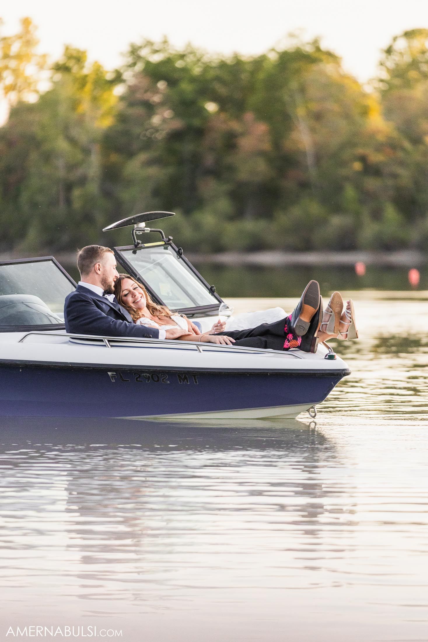 A couple relaxing together in a boat on a serene lake during sunset.
