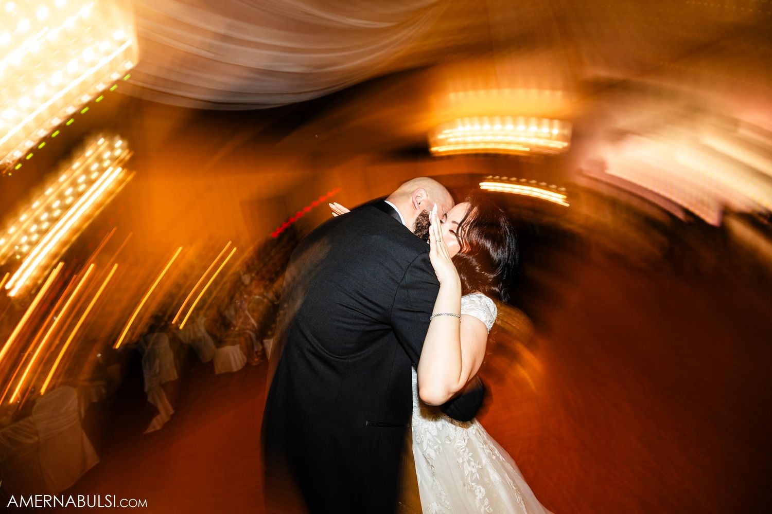 A couple shares their first dance at their wedding reception with artistic motion blur effects.