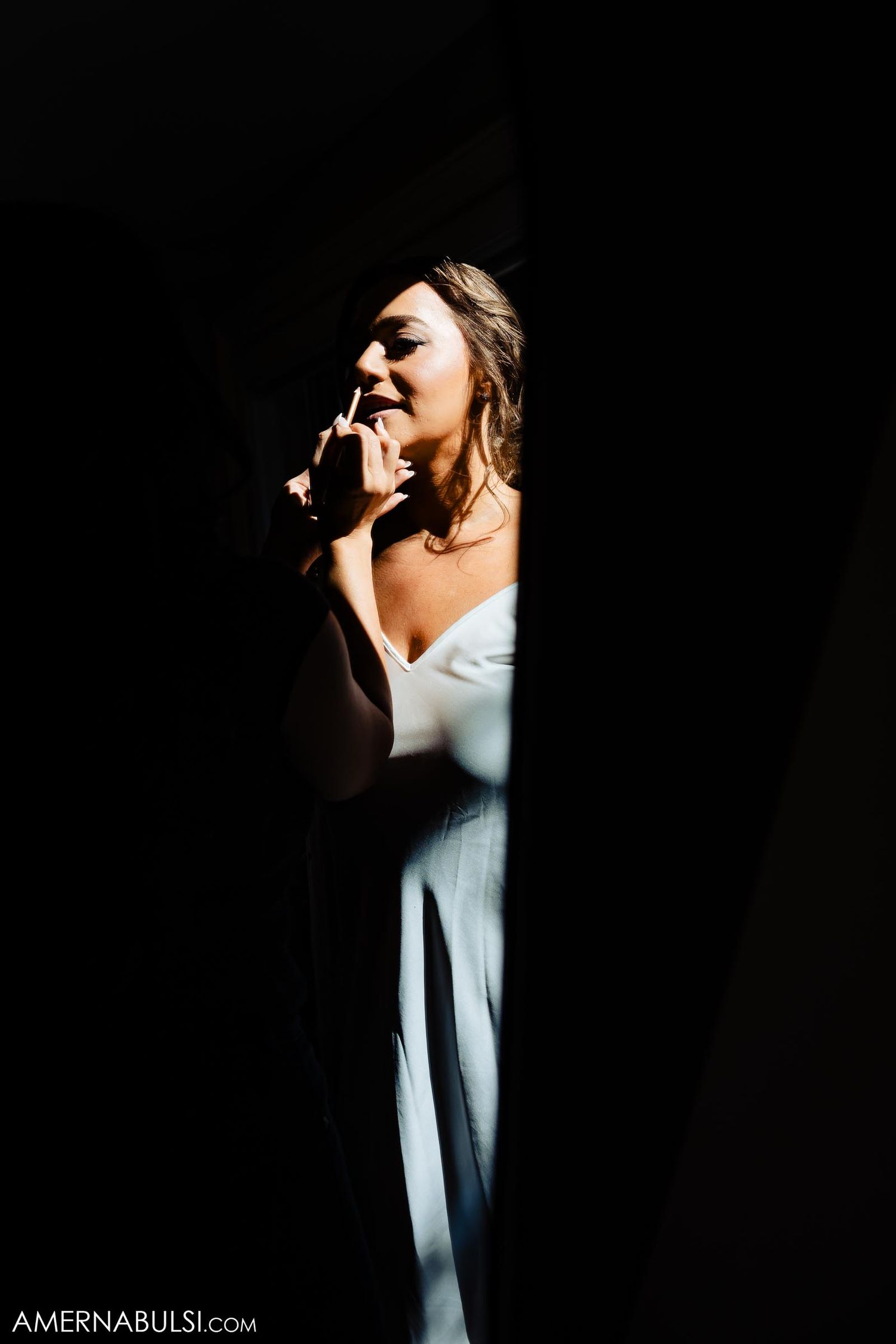 Dramatic lighting captures a figure in white against a dark background.